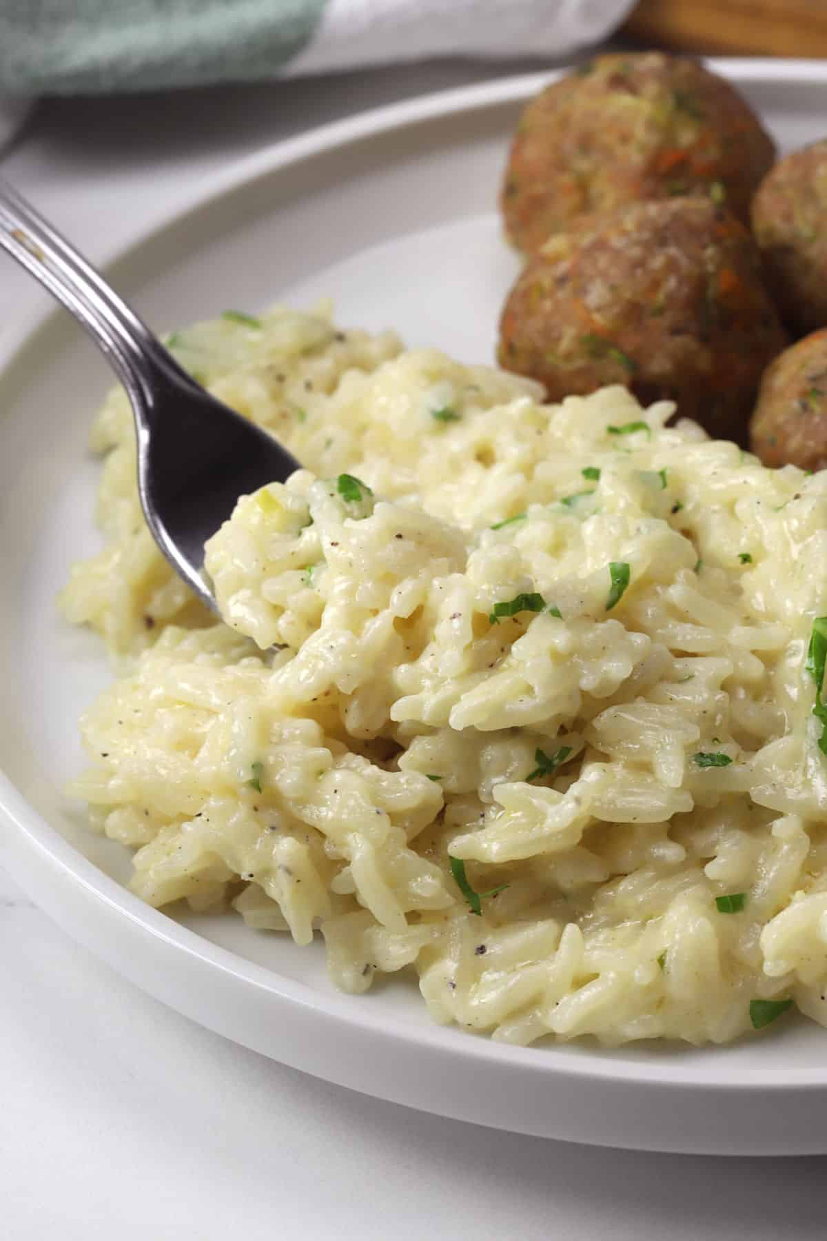 Creamy garlic parmesan rice on a fork.