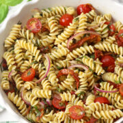 Sun-dried tomato pasta salad in a scalloped serving bowl.