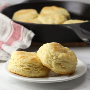 A white plate with two buttermilk biscuits.