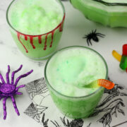 Two decorated glasses filled with green sherbet punch.