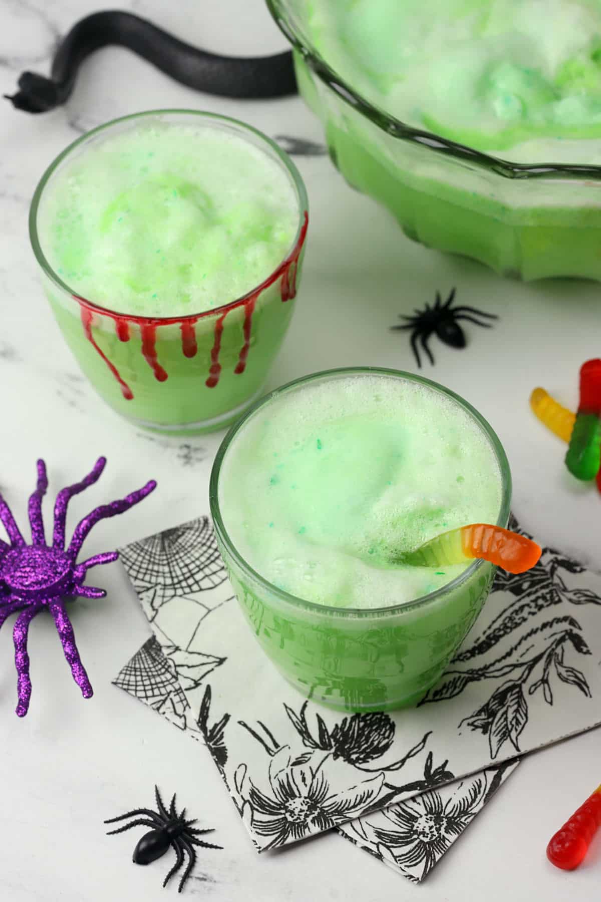 Two decorated glasses filled with green sherbet punch.