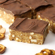 Close up of peanut butter pretzel bars sliced on a piece of parchment.