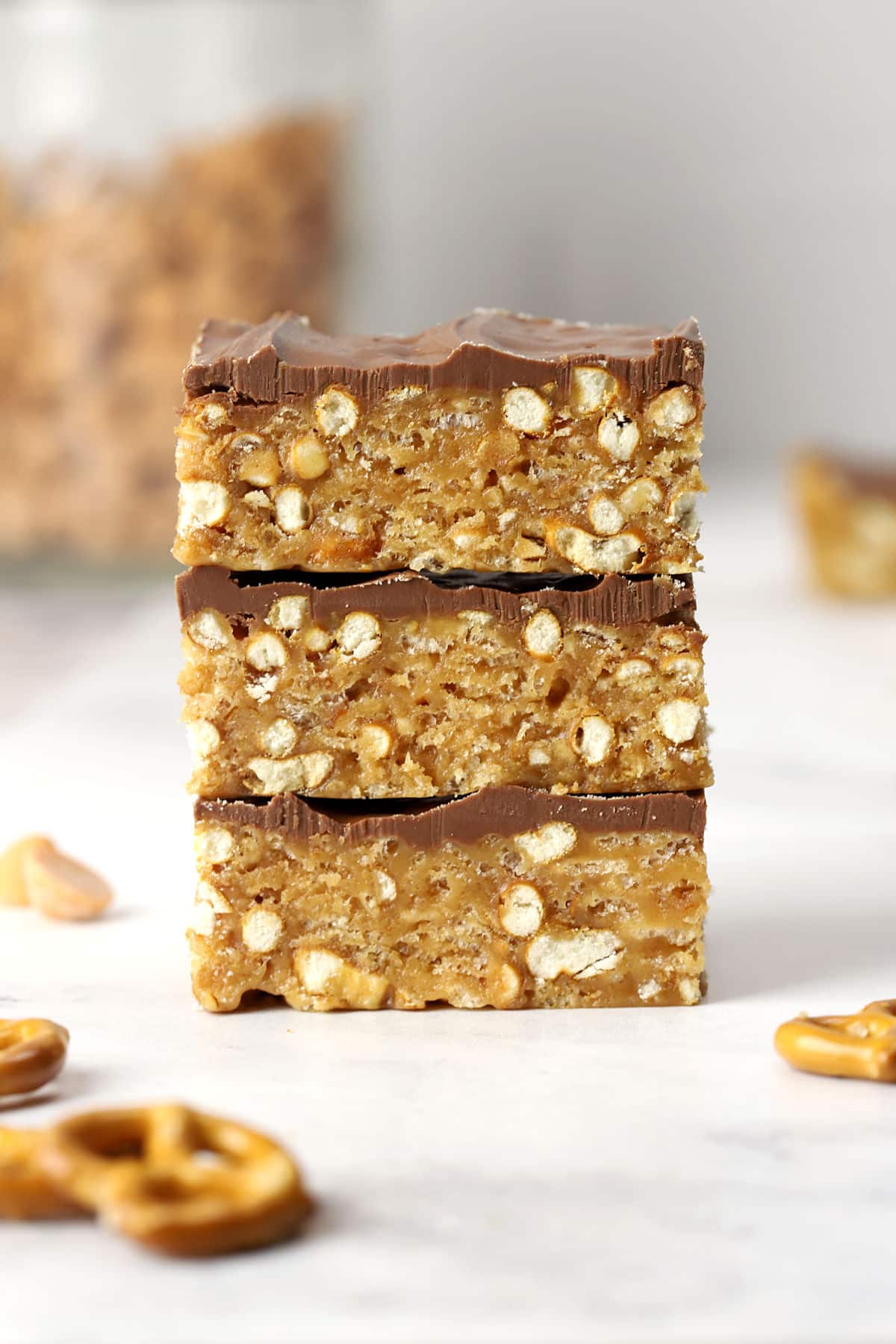 A stack of three peanut butter pretzel bars on a counter top.