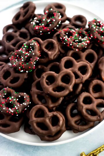 A white plate of chocolate covered pretzels.