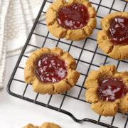 Peanut butter thumbprint cookies on a cooling rack.