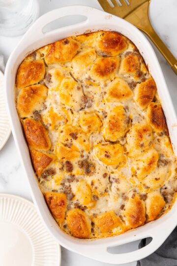 A white baking dish filled with biscuit and gravy casserole.