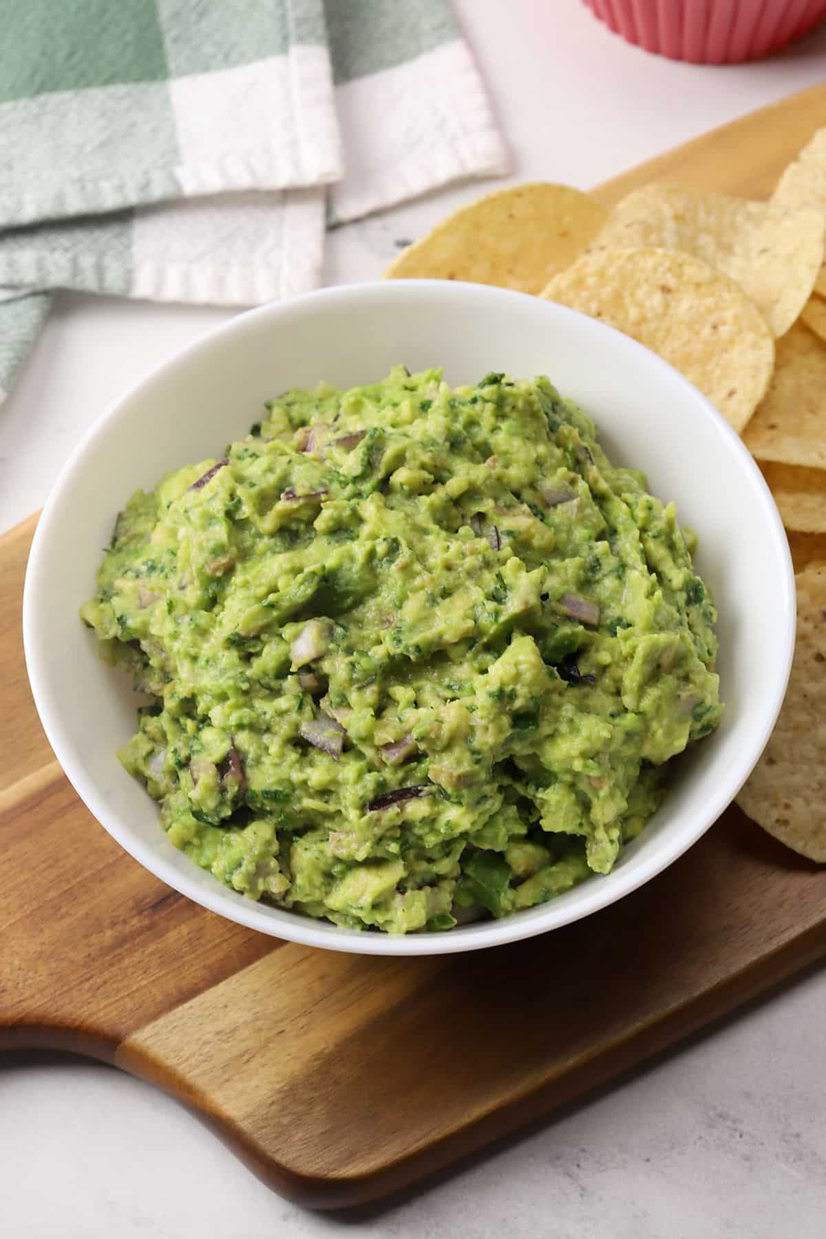 A white serving bowl filled with guacamole.