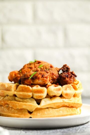 A white plate of chicken and waffles.