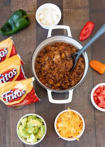 A stock pot of Frito pie ingredients with toppings.