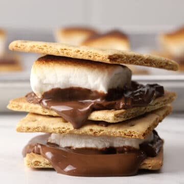 Two melty s'mores stacked on a countertop.