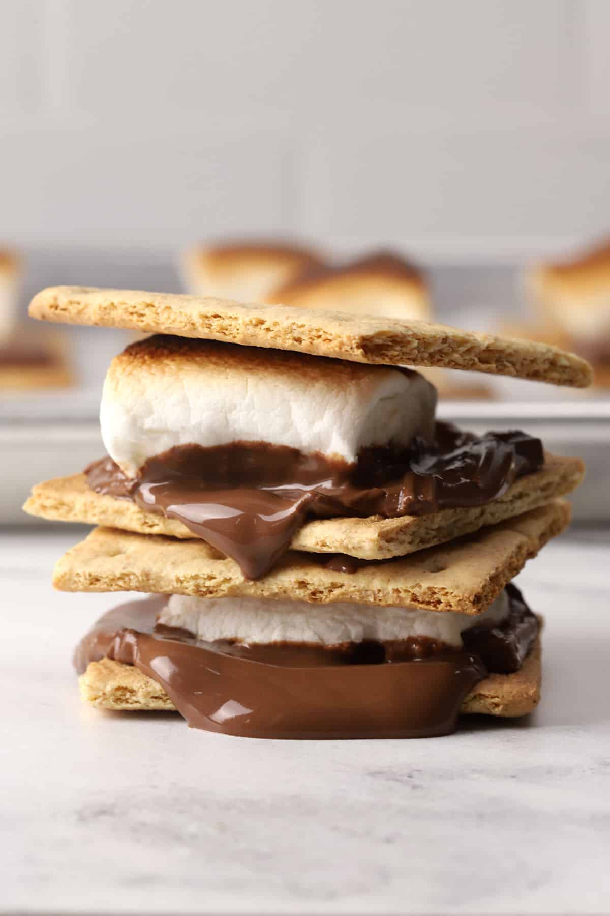 Two melty s'mores stacked on a countertop.