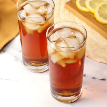 Two glasses of sweet tea filled with ice.