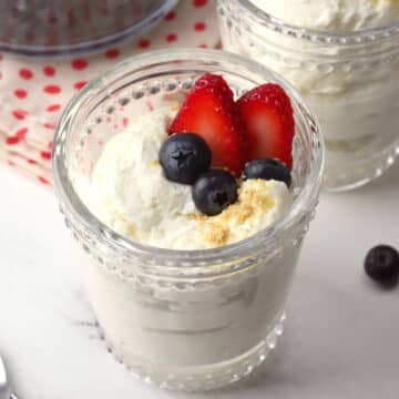 A small dessert glass filled with cheesecake mousse and berries.