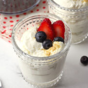 A small dessert glass filled with cheesecake mousse and berries.