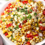 A serving bowl filled with grilled street corn salad.