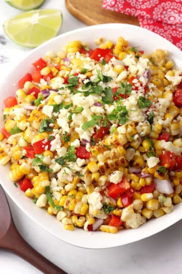 A serving bowl filled with grilled street corn salad.