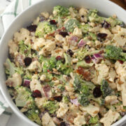 A serving bowl filled with broccoli cauliflower salad.