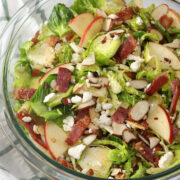 A glass serving bowl filled with hot honey brussels sprouts salad.