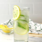 A lemon mint cooler garnished with a lemon slice in a highball glass.