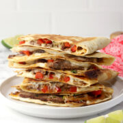 A stack of sliced steak quesadillas on a plate.