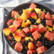 A serving bowl filled with summer fruit salad.