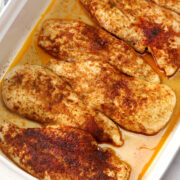 Juicy oven roasted chicken breasts in a casserole dish.