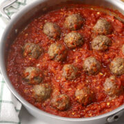 A saute pan filled with homemade meatballs in marinara sauce.