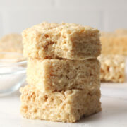 Three salted caramel rice krispies treats stacked on a countertop.