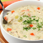 Creamy chicken and rice soup in a bowl with a spoon.