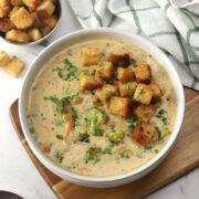 A bowl of smoked gouda broccoli soup with croutons on top.