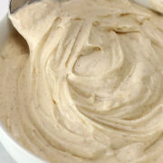 Brown butter cream cheese frosting in a bowl with a spoon.