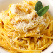 Butternut squash pasta in a bowl with sage leaf garnish.