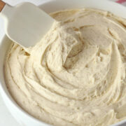 A spatula in a bowl of cinnamon buttercream frosting.