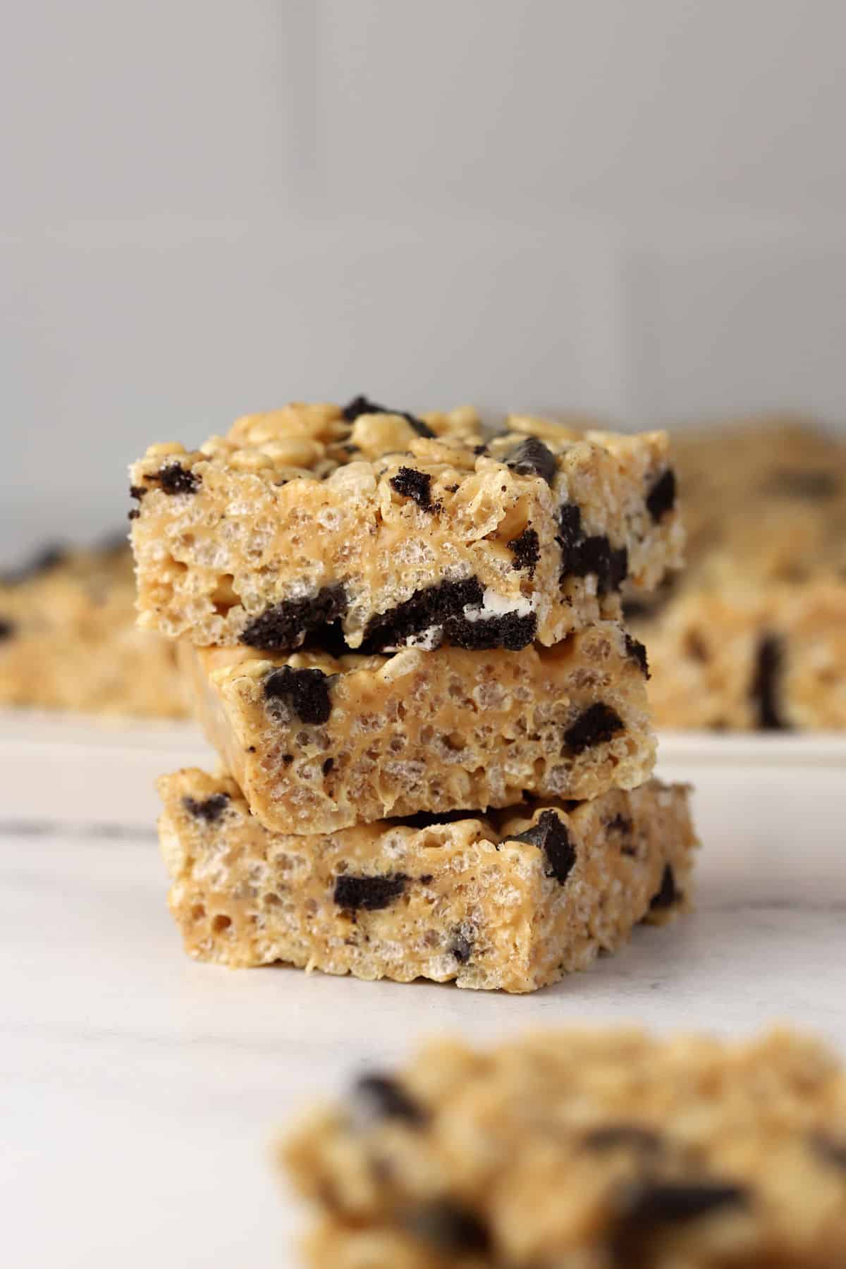 Peanut butter Oreo rice krispies treats stacked on a counter top.
