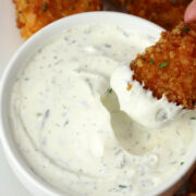 A chicken nugget being dipped into homemade ranch dip.