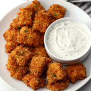 Spicy chicken nuggets on a plate with a bowl of ranch dip.
