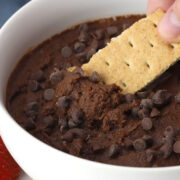 Dipping a graham cracker into brownie batter dip.