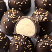 Split open chocolate tahini balls on a stack of others.