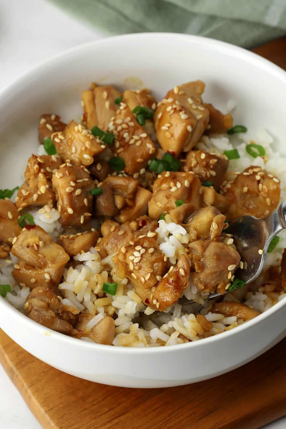A forkful of chicken teriyaki and rice.