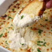 Dipping crostini into garlic bread dip.
