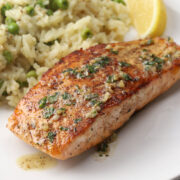 Pan-seared salmon on a plate with rice.