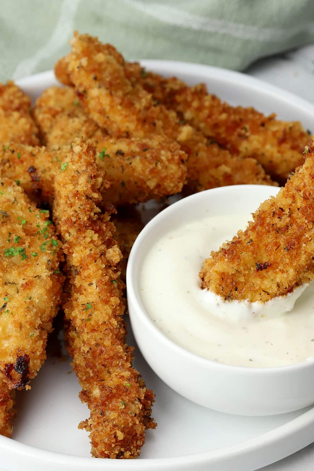 Ranch chicken tenders on a plate with dipping sauce.