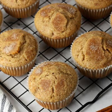 Cinnamon walnut muffins lined up on a cooling rack.