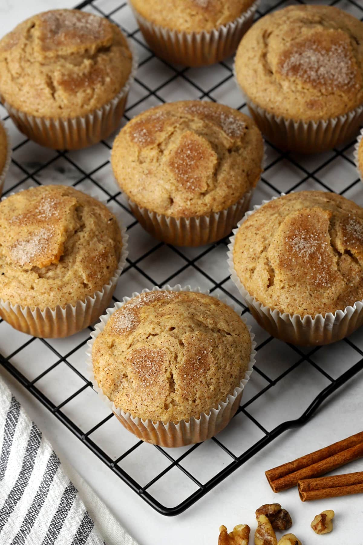 Cinnamon walnut muffins lined up on a cooling rack.