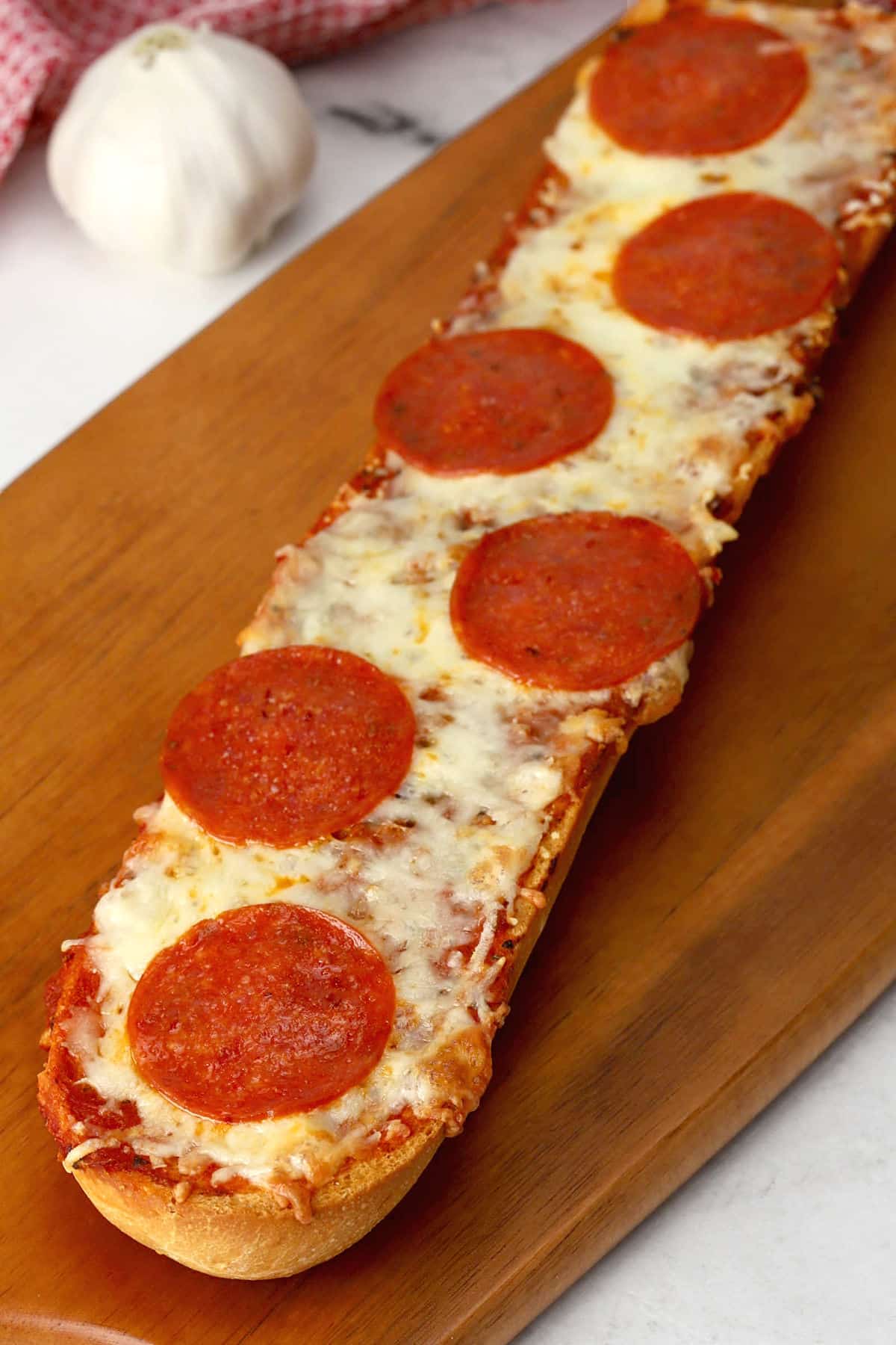 Garlic bread pizza on a cutting board.