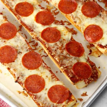 Several garlic pan pizzas on a sheet pan.