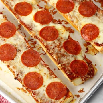 Several garlic pan pizzas on a sheet pan.
