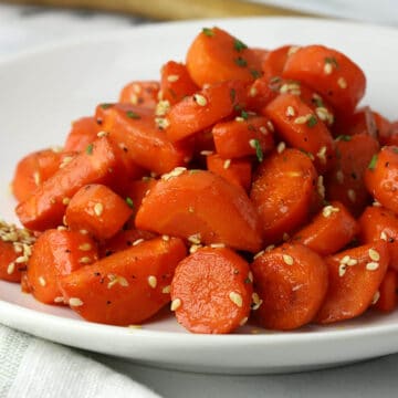 Closeup of stovetop glazed carrots on a serving plate.