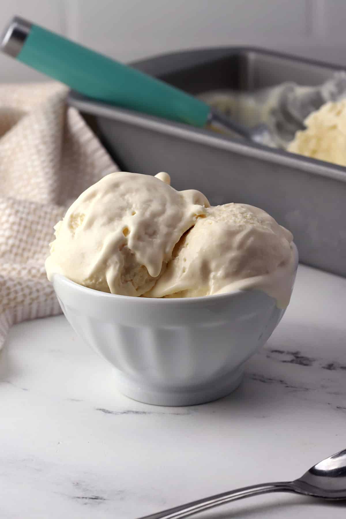 A white bowl filled with melting vanilla ice cream.