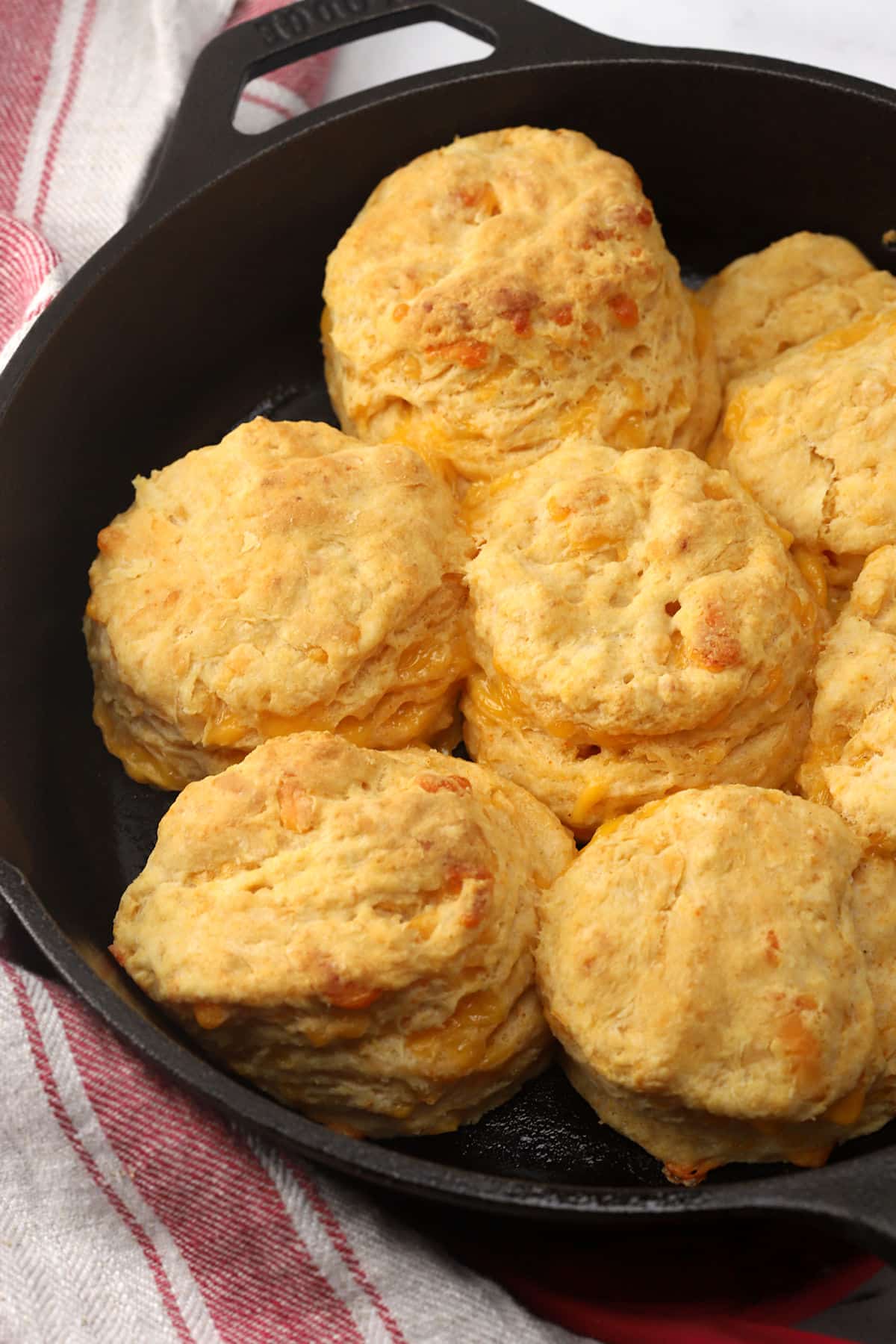 A cast iron skillet filled with cheesy biscuits.